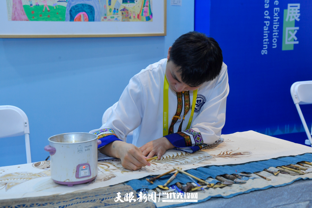 JZS_0665---2024年8月21日，2024中國-東盟教育交流周在貴陽市貴安新區(qū)中國-東盟教育交流周永久會址開幕。圖為2024年中國-東盟特殊兒童少年藝術(shù)作品展現(xiàn)場，一名手工藝人在制作蠟染 貴州日報天眼.jpg